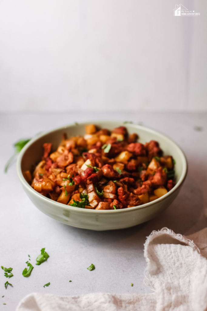 A bowl of Papas con Chorizo, a flavorful Mexican dish made with seasoned chorizo and diced potatoes, garnished with fresh cilantro.