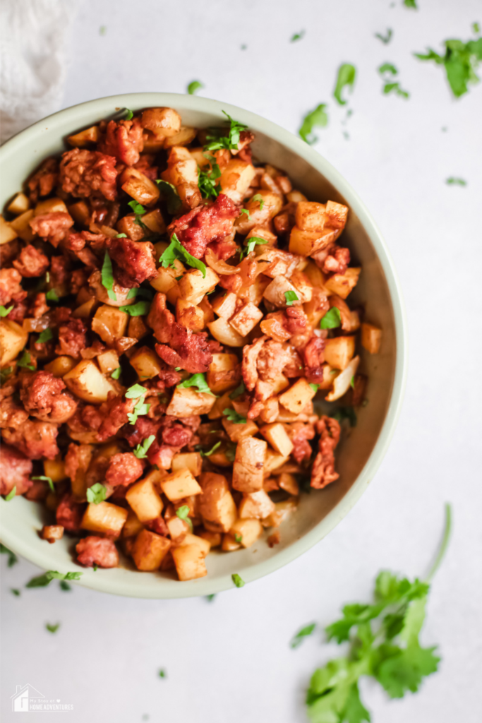 A top view of Papas con Chorizo, a vibrant Mexican dish of diced potatoes and seasoned chorizo, garnished with fresh cilantro.