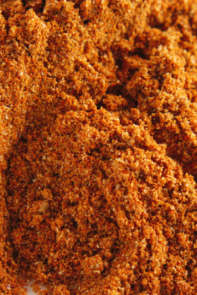 Close-up of homemade sazon seasoning blend, showcasing a vibrant mix of Latin spices used in gluten-free and salt-free cooking.