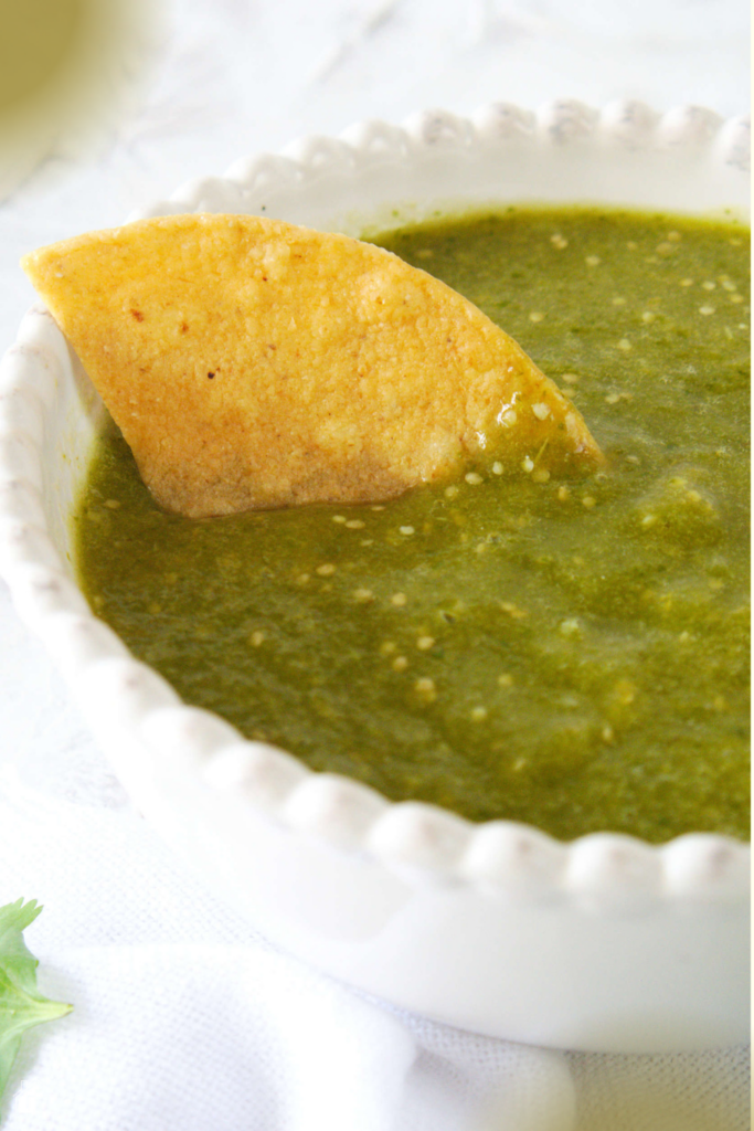 Served salsa verde with a chip on top.