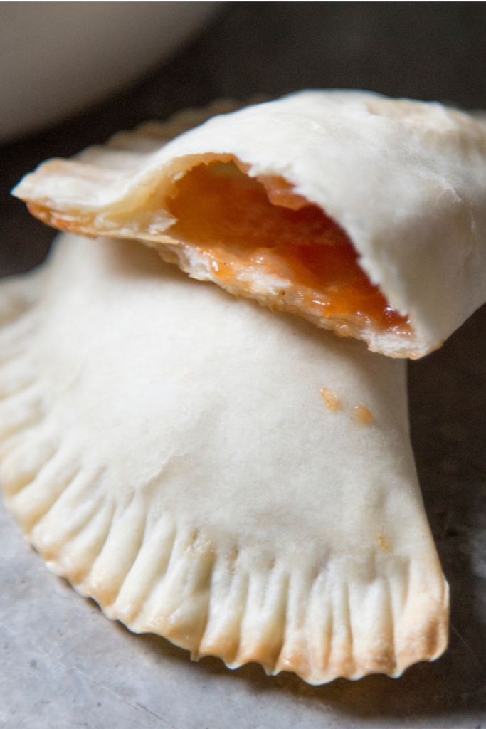 Golden brown baked guava and cheese empanadas with a flaky crust, showcasing the sweet guava filling inside, ready to be enjoyed as a tasty snack or dessert.