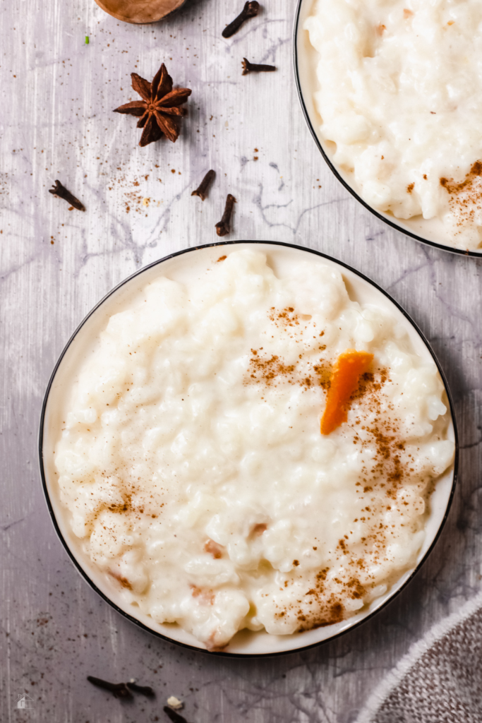 Close-up of a bowl of creamy Arroz con Leche, garnished with cinnamon, orange peel, and star anise, perfect for a traditional Puerto Rican dessert or comforting Latin American treat.