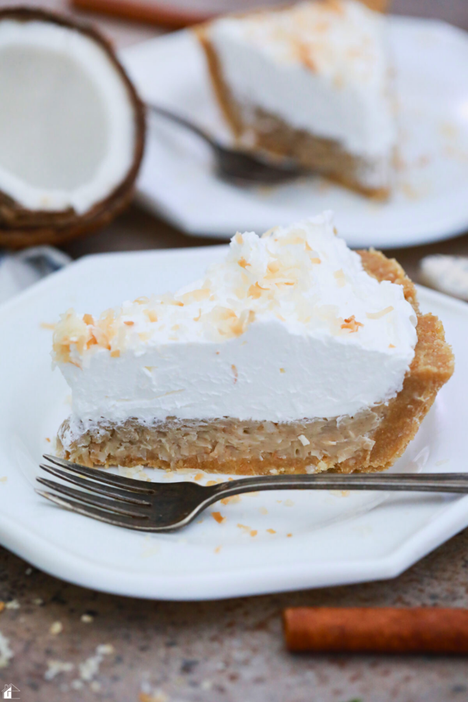 A slice of creamy Coconut Rum Coquito Cream Pie topped with whipped cream and toasted coconut, perfect for holiday desserts, festive pies, and Puerto Rican-inspired recipes.