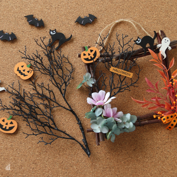 DIY Halloween wreath crafting materials including branches, pumpkins, bats, and florals, perfect for creating simple and fun Halloween wreaths at home.