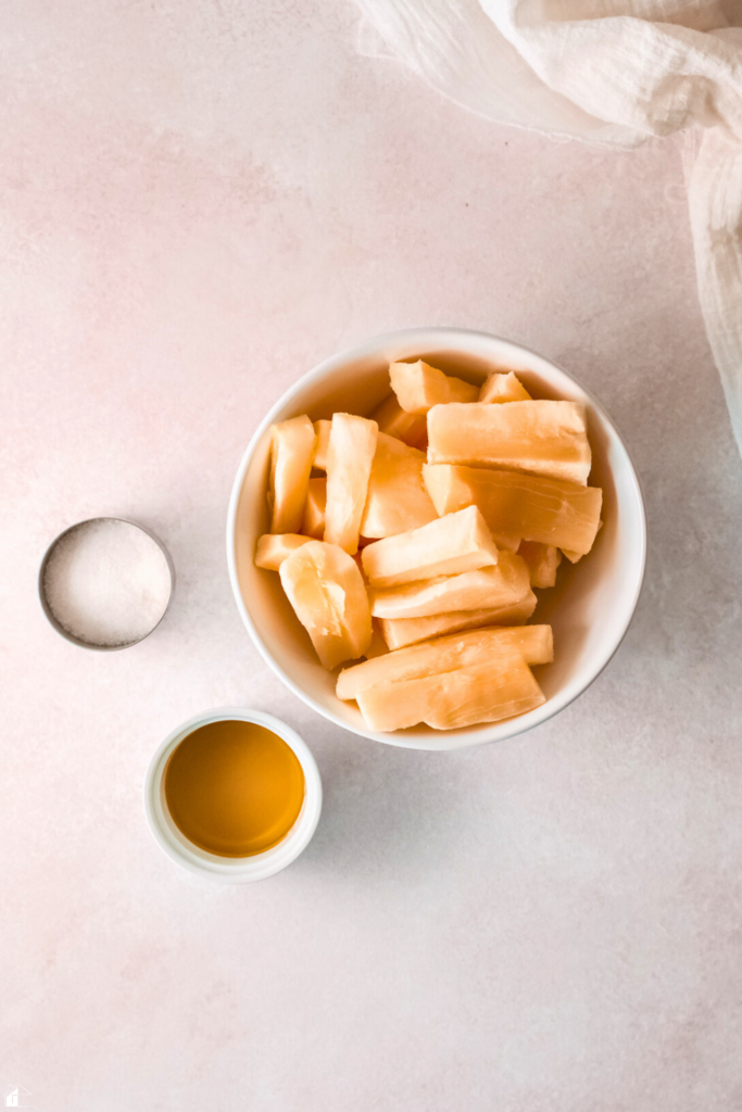 Ingredients for easy 3-ingredient yuca fries, including peeled yuca, vegetable oil, and salt, ready for baking to create crispy, gluten-free fries.