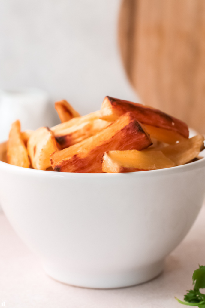 A bowl of golden, crispy baked yuca fries, perfectly cooked with a light and crunchy texture, ready to serve as a tasty gluten-free snack or side dish.