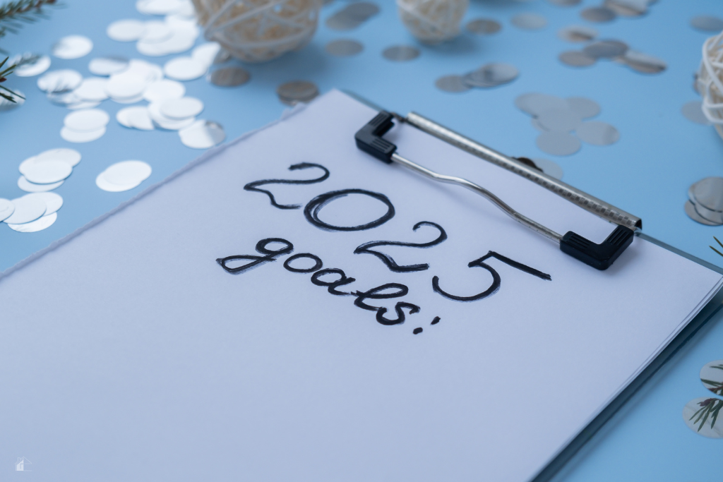 A clipboard with "2025 goals" written on paper, surrounded by festive decorations, symbolizing goal setting, quarterly planning, and achieving success in the new year.