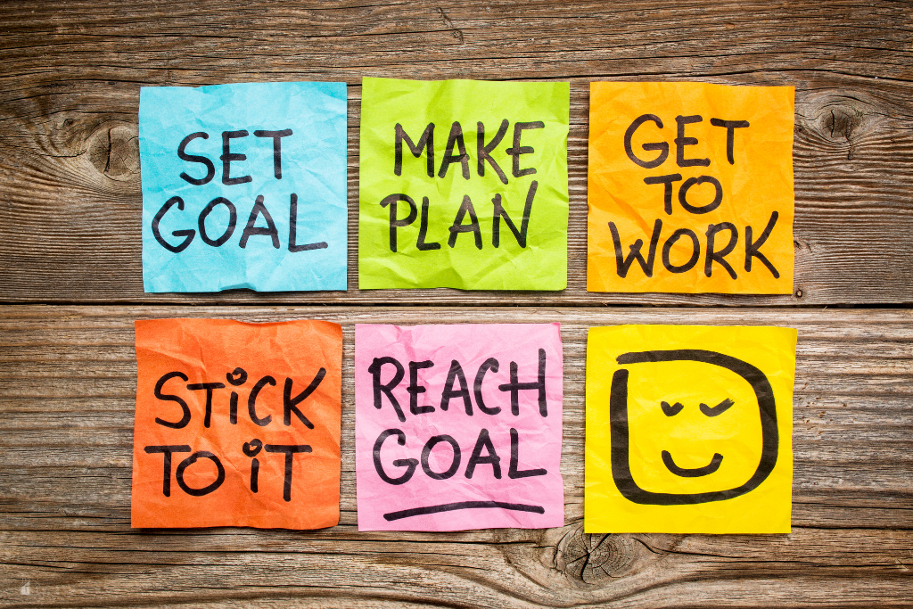 Colorful sticky notes with motivational phrases about goal setting, planning, and achieving success, representing the benefits of quarterly goals and staying organized.