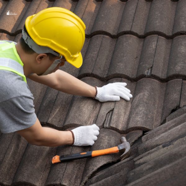 Worker man replace tile of the old roof.