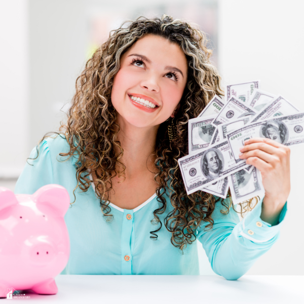 A woman looking up holding bills in one hand, and a pink piggy bank on the side.