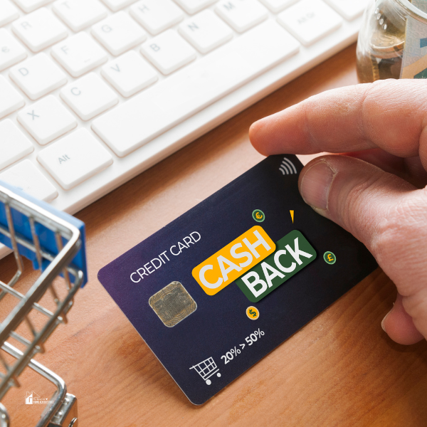 a human hand holding a cash back credit card