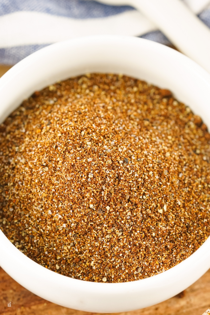 A close-up of homemade chili seasoning blend in a white bowl, featuring a rich mix of spices including chili powder, cumin, and cayenne pepper, perfect for creating the best chili recipe.