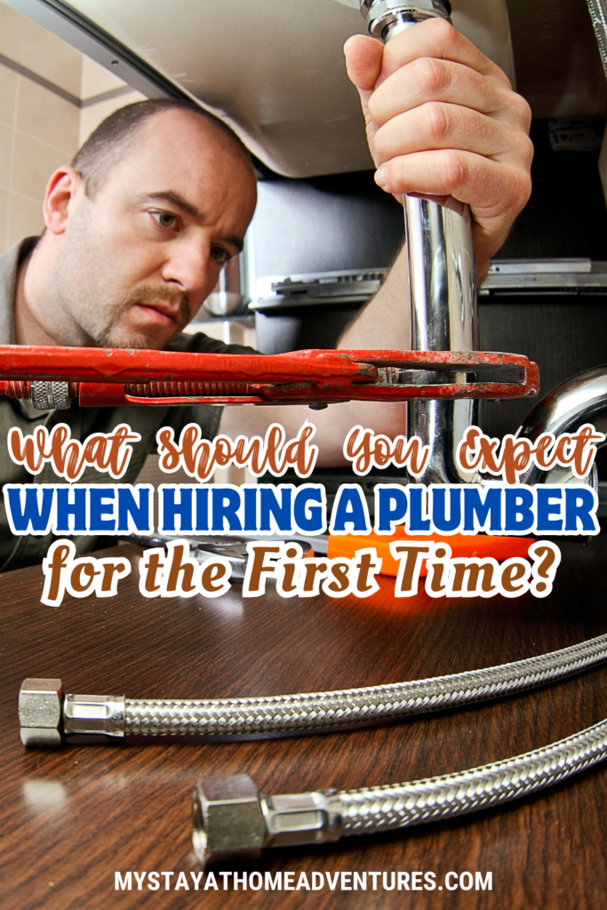 A plumber using a wrench to fix a pipe under a sink, illustrating what to expect when hiring a plumber for the first time.