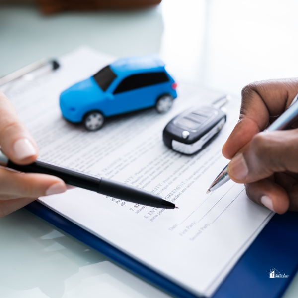 Person's Hand Signing Car Loan Agreement Contract