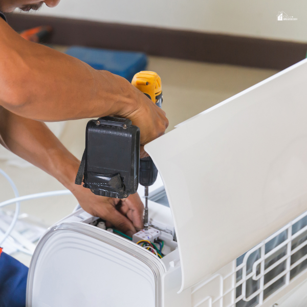 Air conditioning technicians install new air conditioners in a home