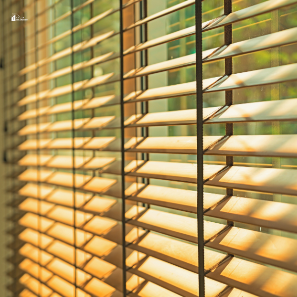 Close-up of wooden blinds with sunlight filtering through, showcasing an effective window furnishing option for privacy and noise reduction.