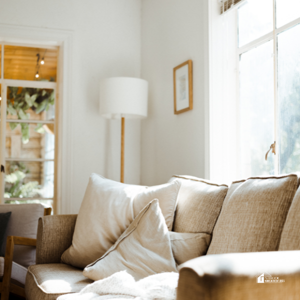 Cozy living room featuring soft beige seating, ample natural light, and simple decor for a warm, budget-conscious home setup.