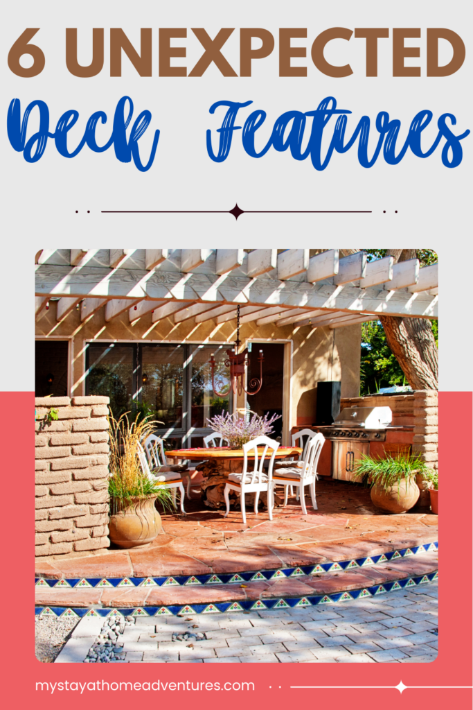 A stylish outdoor patio with a pergola, hanging chandelier, dining table, and built-in grill, surrounded by plants and decorative steps.