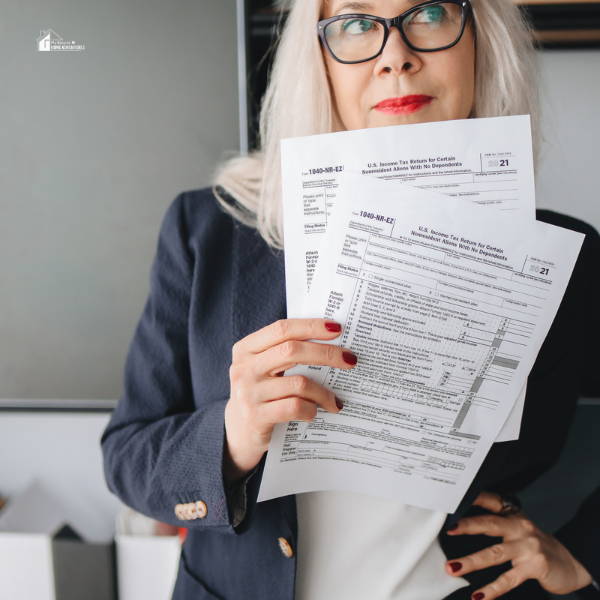 A professional woman holding completed tax forms, emphasizing the importance of reliable tax preparation software like ProSeries for accurate and efficient filing.