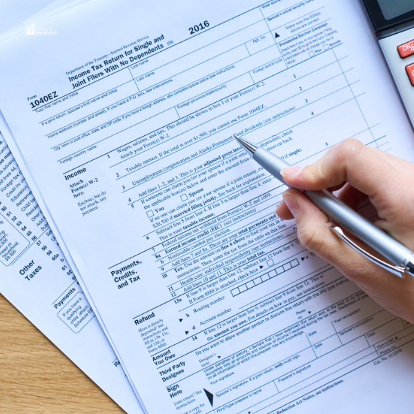 A close-up of a hand filling out a tax form with a pen, demonstrating the ease of organizing tax documents using ProSeries software tools.