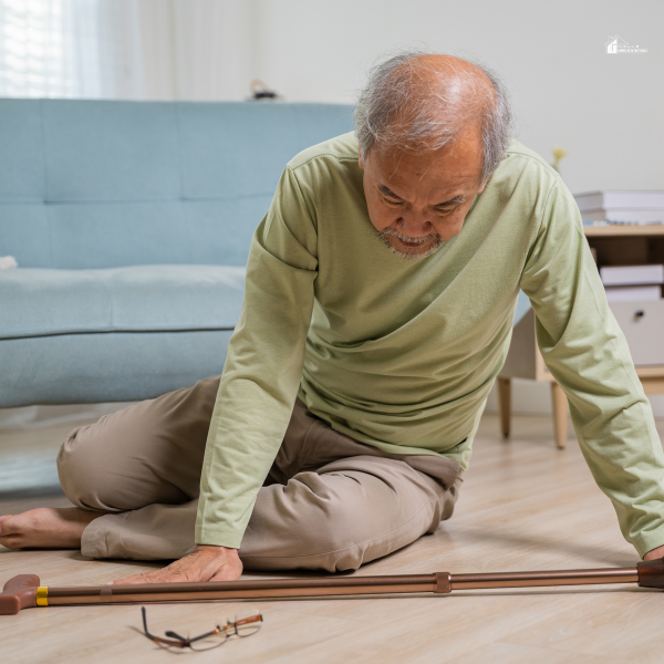 An elderly man sitting on the floor next to his cane and glasses after a fall, highlighting the need for reliable Canadian fall detection solutions.