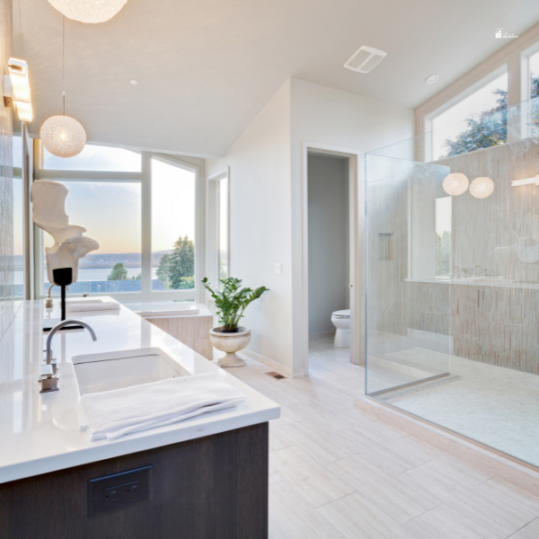 A spacious, light-filled bathroom with a glass shower, contemporary fixtures, and a scenic window view.