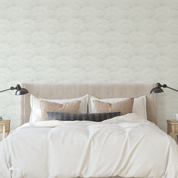 A modern bedroom featuring a beige upholstered headboard, white bedding, and an elegant scalloped-patterned wallpaper.