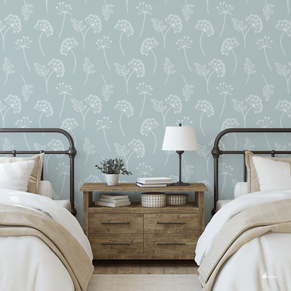 A cozy bedroom with twin metal-framed beds, a wooden nightstand, and soft blue floral-patterned wallpaper.