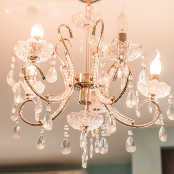 A close-up of an elegant crystal chandelier with intricate details, casting a warm, luxurious glow.