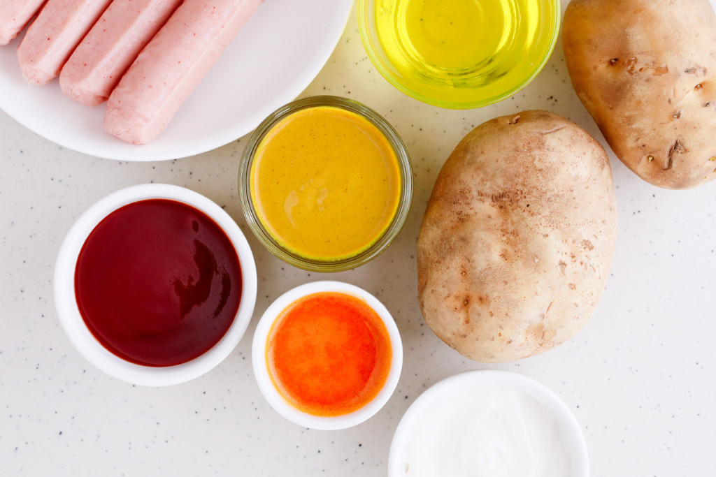 This image beautifully showcases the key ingredients for making Salchipapas: hot dogs, potatoes, and flavorful toppings like ketchup, mustard, aji sauce, and mayonnaise. Perfect for illustrating how easy it is to prepare this Peruvian street food!