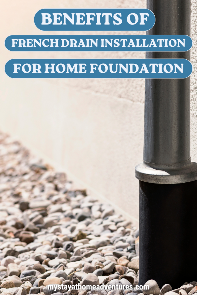 A section of a home foundation with a metal drainage pipe and gravel stones placed along the base, illustrating a French drain installation for water management.