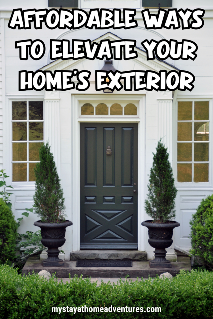 A classic home entrance with a dark green front door, two symmetrical potted plants, and neatly trimmed hedges, showcasing an inviting and well-maintained exterior.