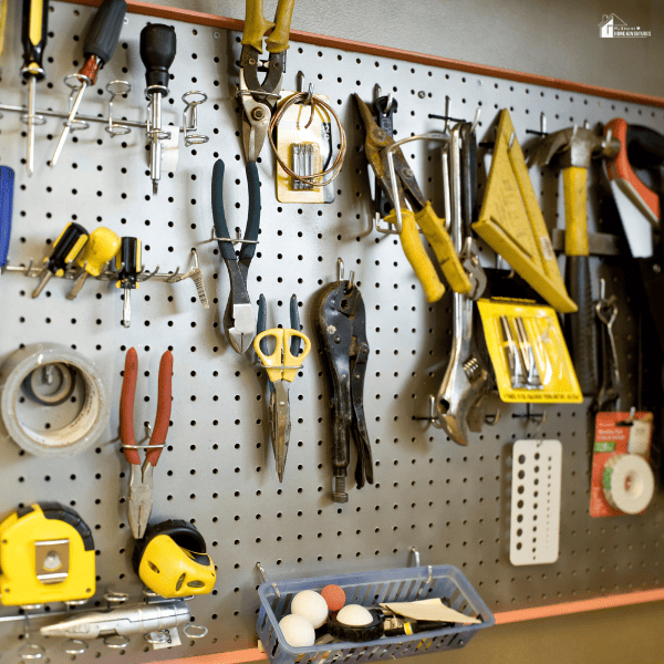 A well-organized tool wall with various hand tools neatly arranged on a pegboard for easy access in a functional workspace.