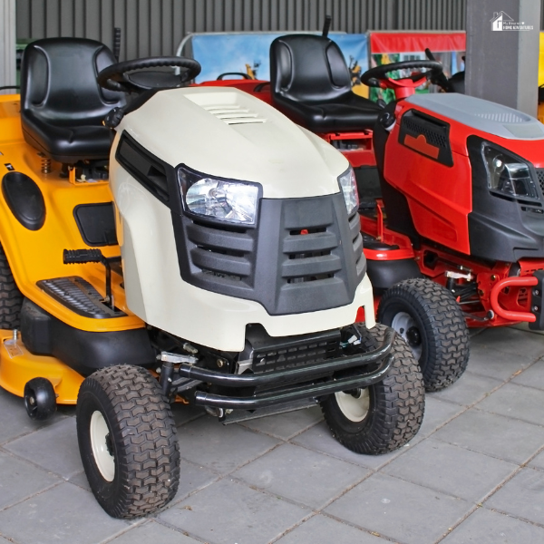 Multiple colorful riding lawn tractors are parked in a display area.