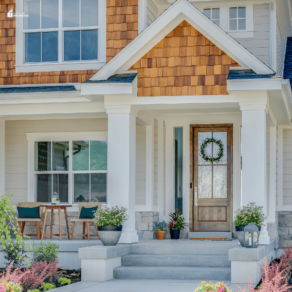 A beautifully designed front porch with potted plants, outdoor furniture, and a welcoming entrance.