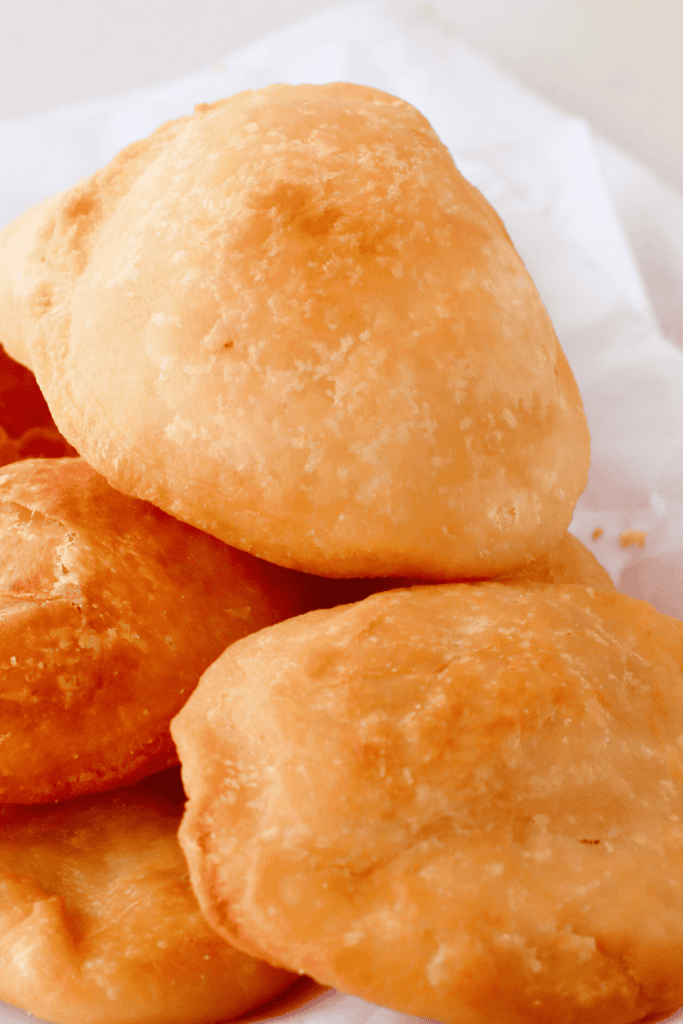 A close-up of freshly fried Puerto Rican arepas, showcasing their golden-brown, crispy exterior and fluffy texture, perfect for serving with stewed beans, picadillo, or melted butter.